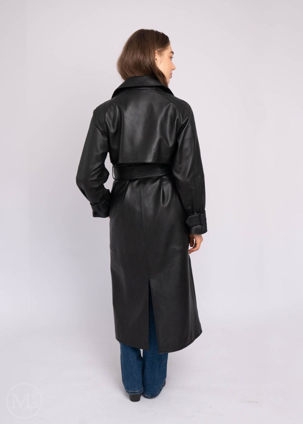 Women wearing a black leather trench coat on a white background