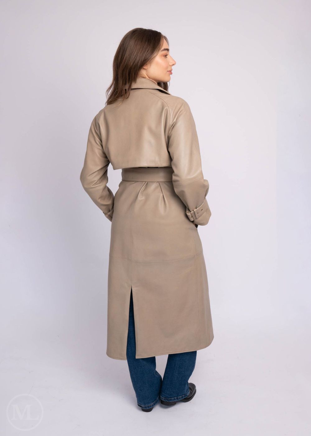 Woman wearing a taupe leather trench coat on a white background