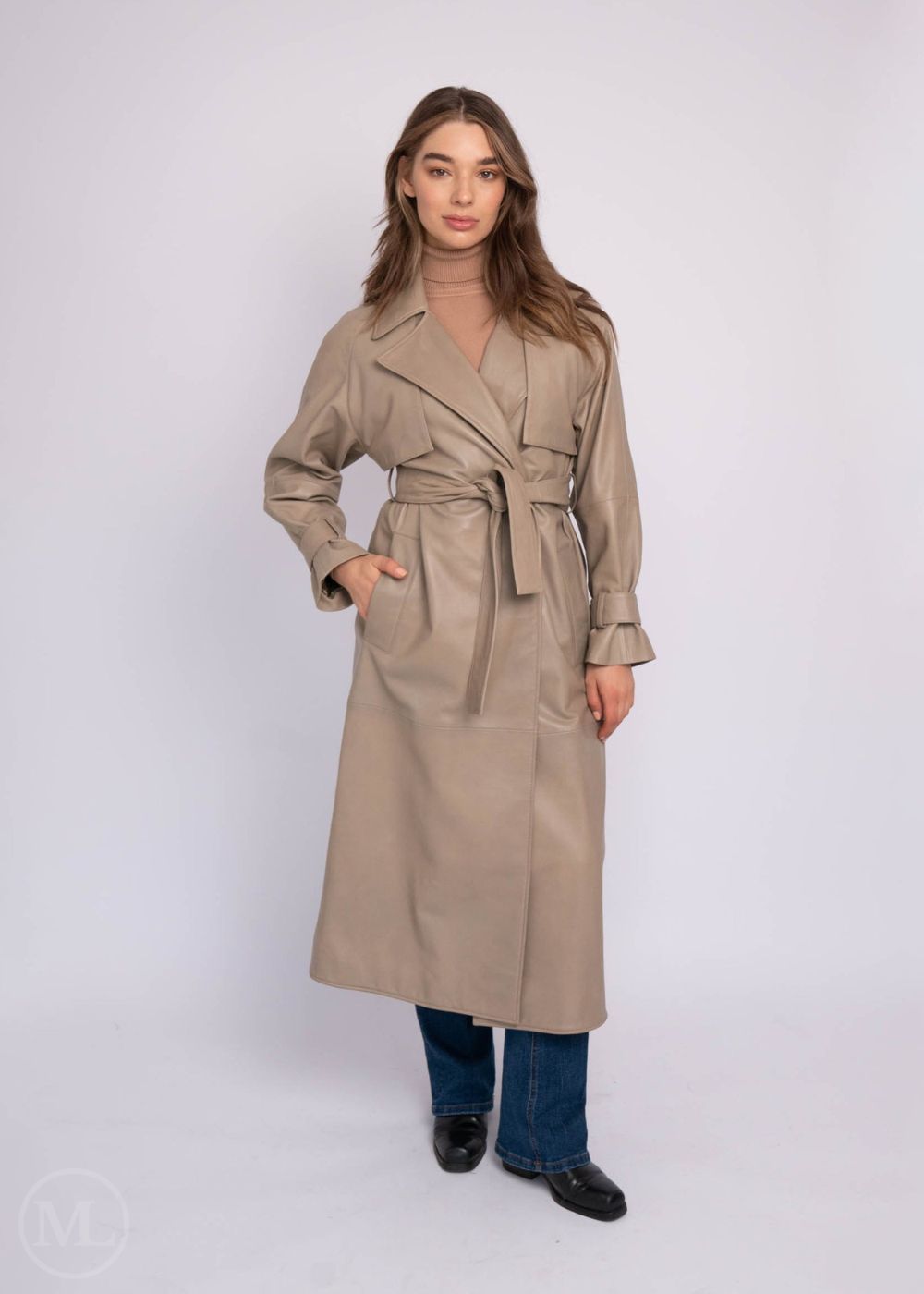 Woman wearing a taupe leather trench coat on a white background