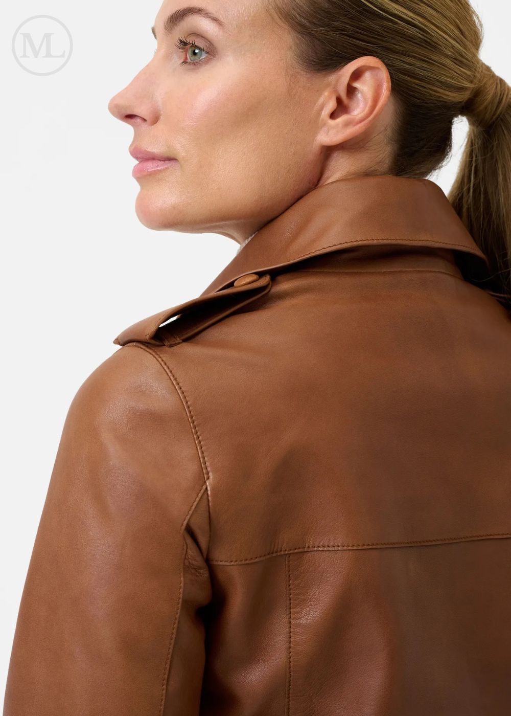 Veste en cuir marron cognac portée par une personne sur fond uni