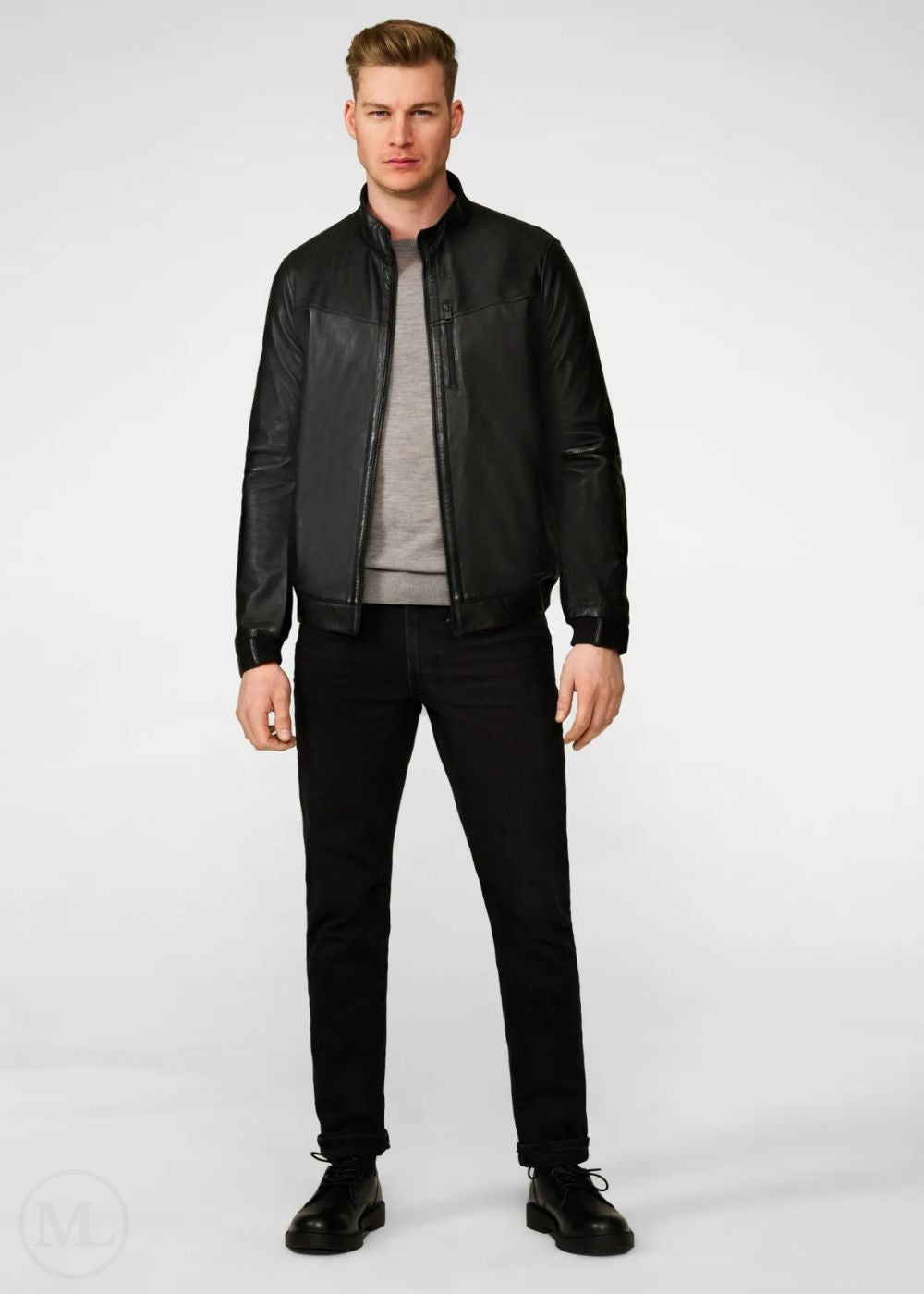 Man wearing a black leather bomber jacket and black pants on a white background