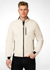 Man wearing a white leather bomber jacket with black accents on a white background