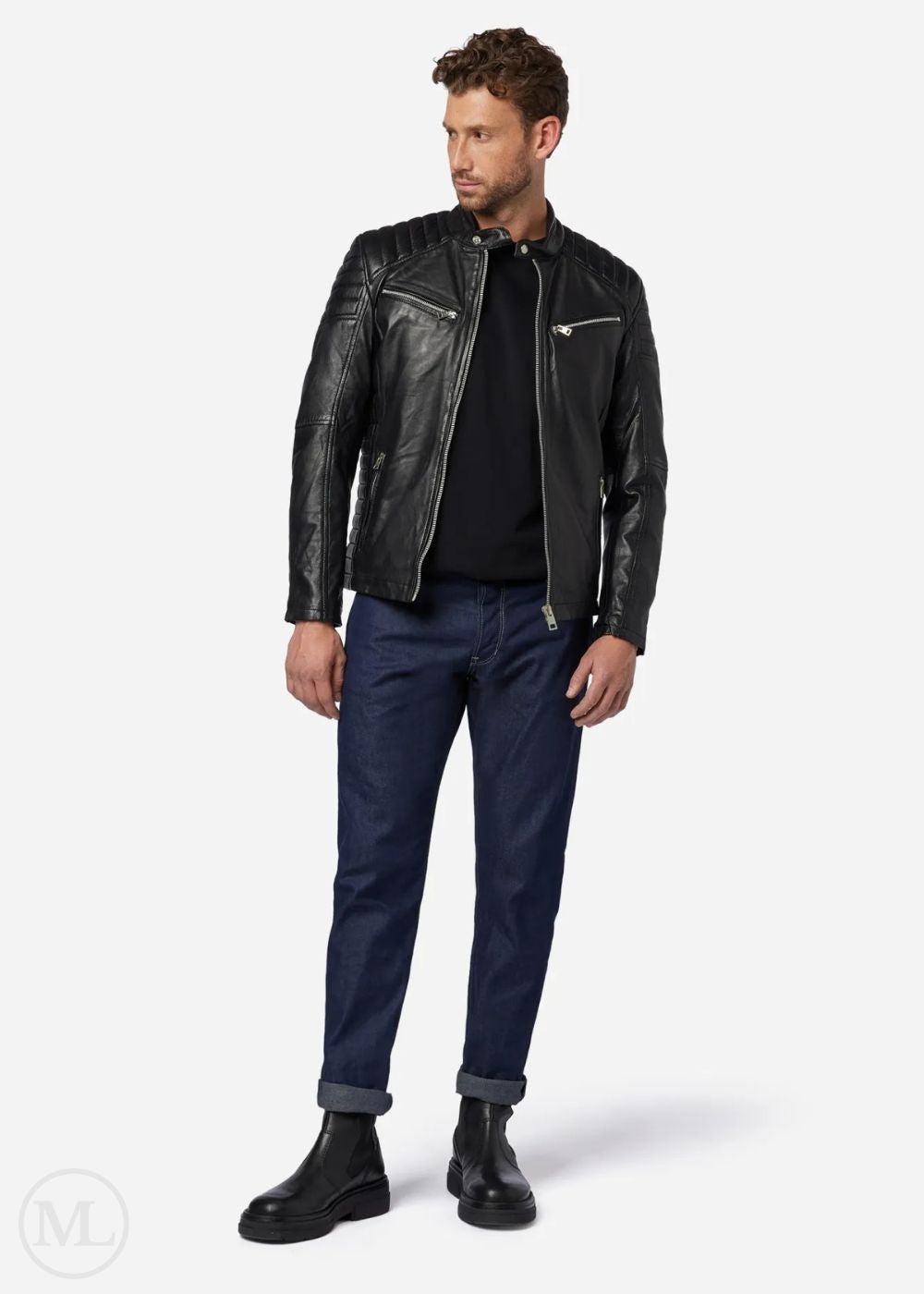 Man wearing a black leather biker jacket, black shirt, and navy pants on a white background