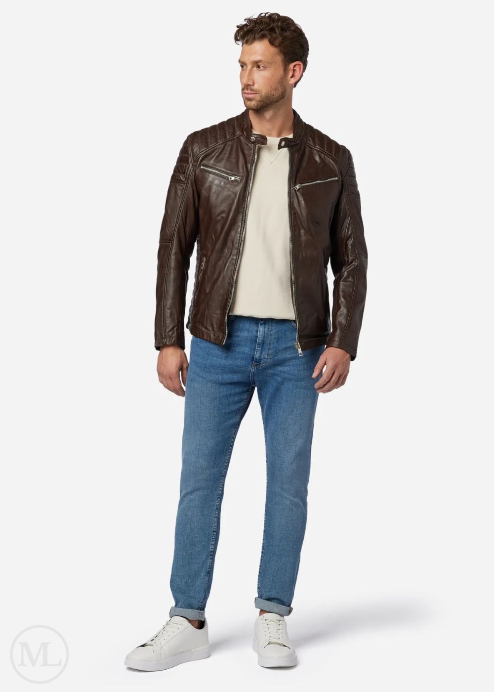 Homme portant une veste de motard en cuir marron, une chemise blanche, un jean bleu et des baskets blanches sur fond blanc