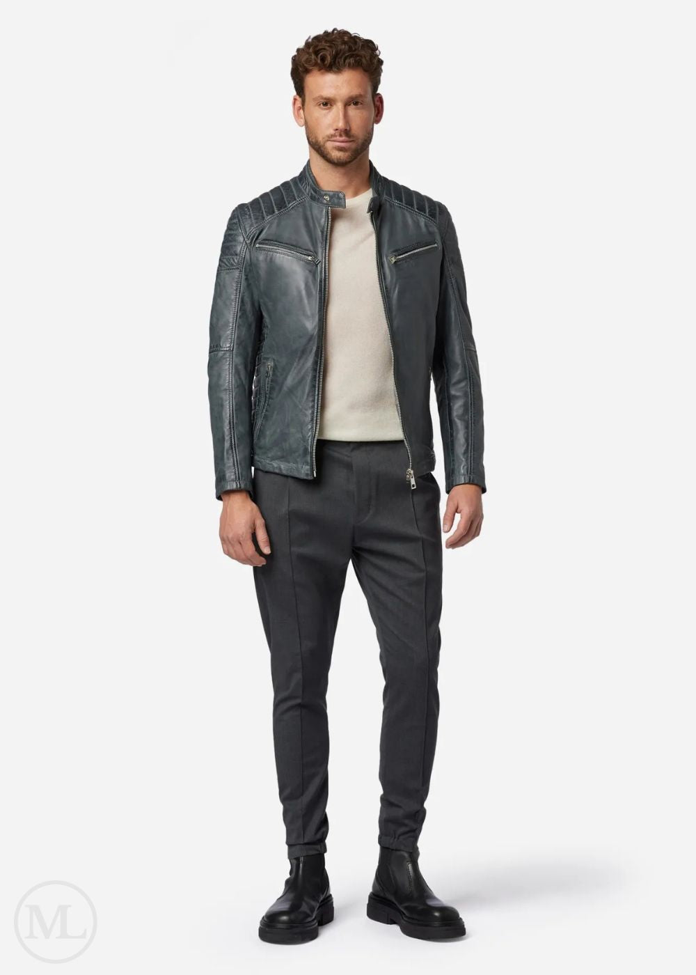 Man wearing a grey leather biker jacket and dark pants on a white background