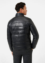 Man wearing a black leather puffer jacket on a white background