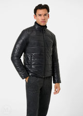 Man wearing a black leather puffer jacket on a white background