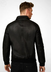 Man wearing a black leather bomber jacket on a white background