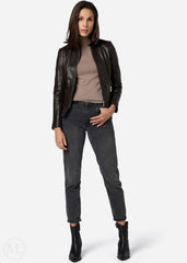 Woman wearing a brown leather jacket, beige top, gray jeans, and black boots on a white background