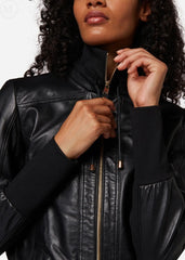 Woman wearing a black leather bomber jacket with a focus on the zipper.