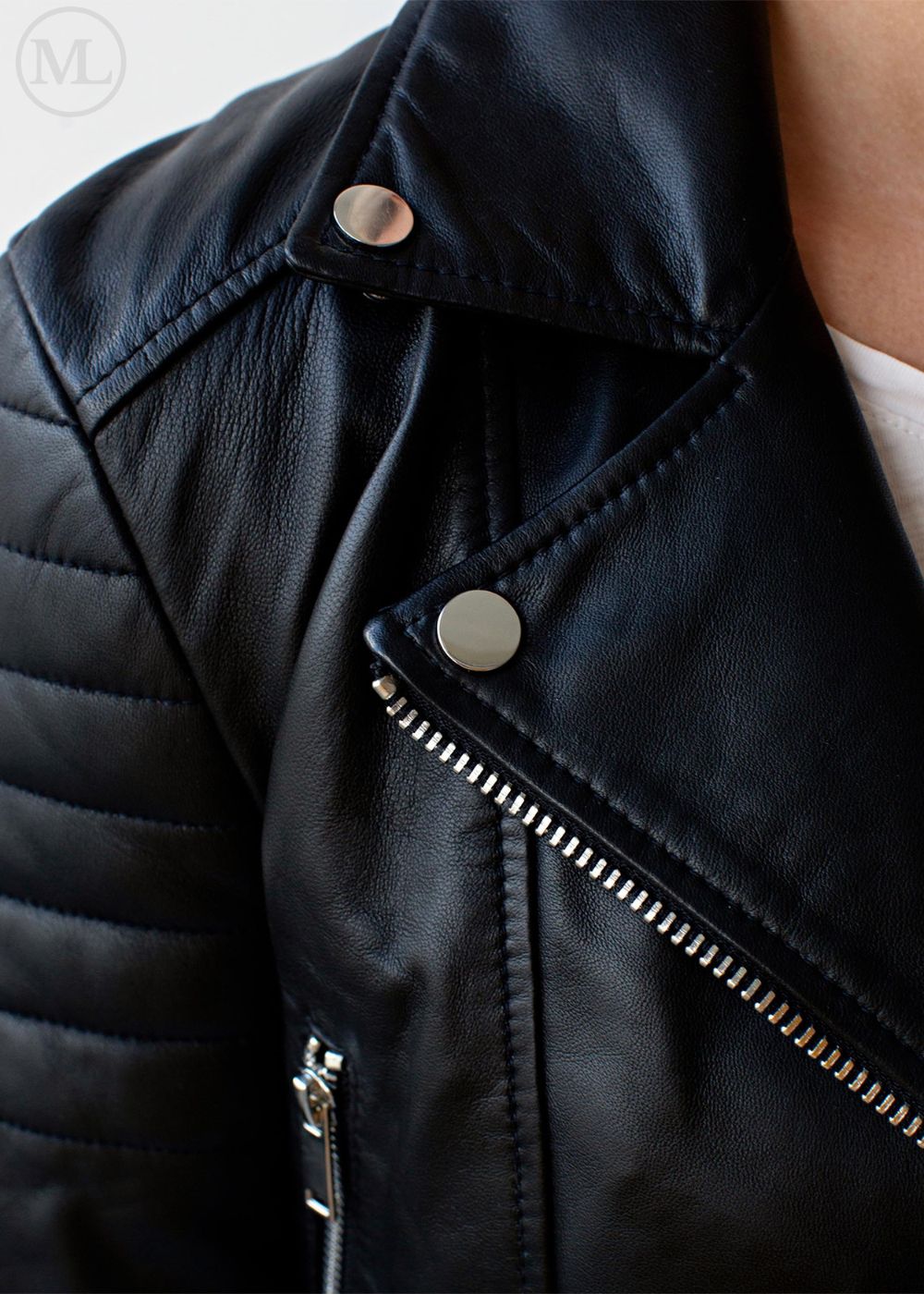 Close-up of a black leather biker jacket with silver buttons and zipper.