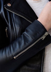 Close-up of a black leather biker jacket with silver zippers