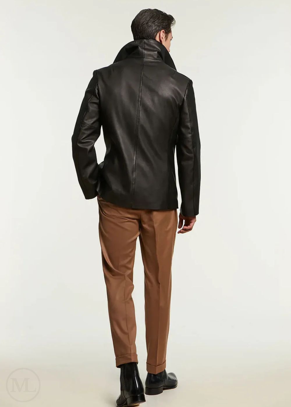 Man wearing a black leather jacket and brown pants on a white background