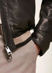 Close-up of a black leather bomber jacket with a zipper worn by a man