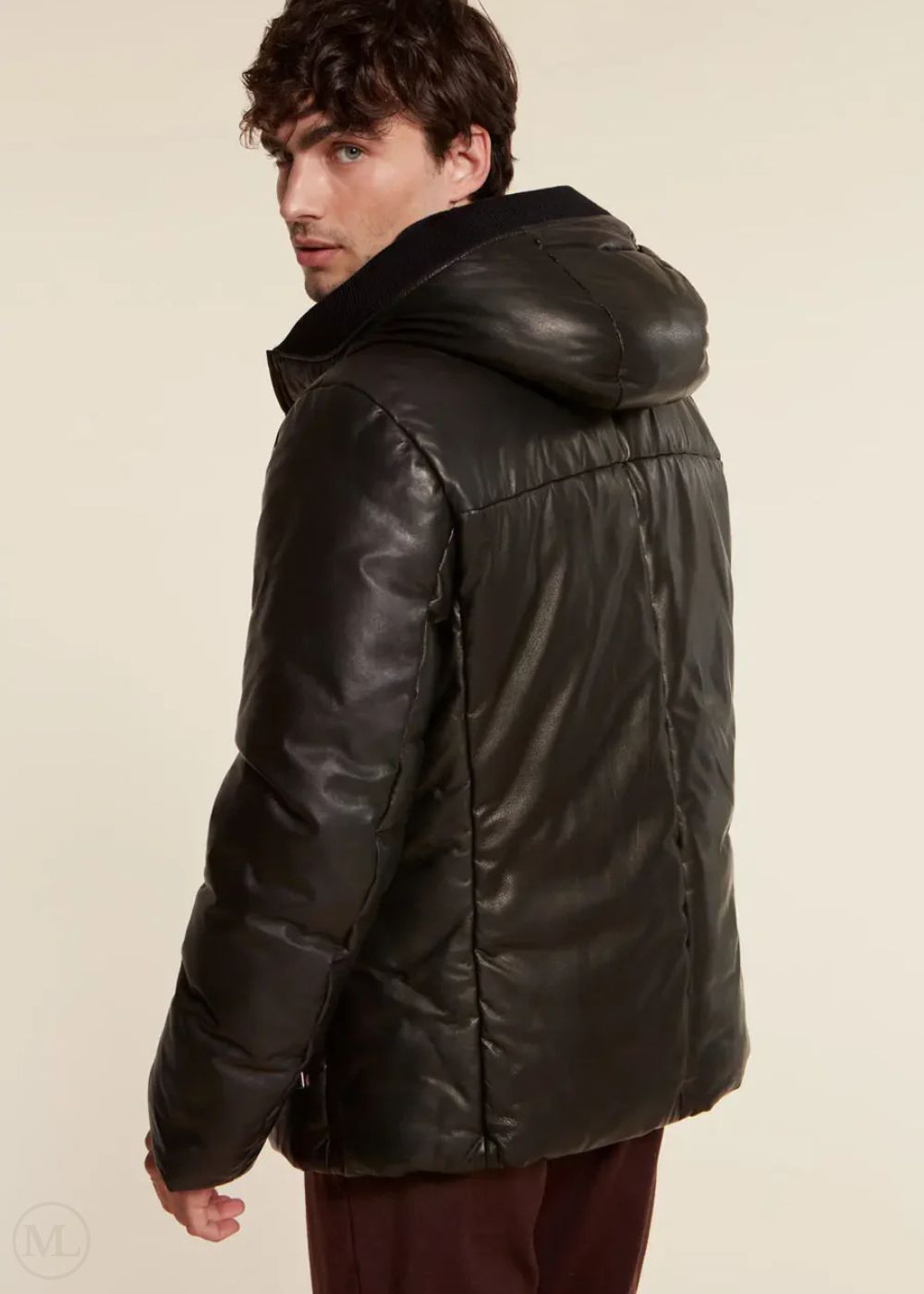 Man wearing a black leather jacket on a beige background