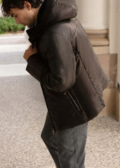 Man wearing a Black leather jacket outdoors on a stone surface.