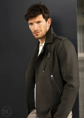 Man wearing a olive kahki  leather  biker jacket against a plain backgrounde