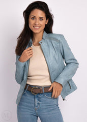 Woman wearing ice blue leather biker
jacket over a beige sweater and blue jeans on a white background