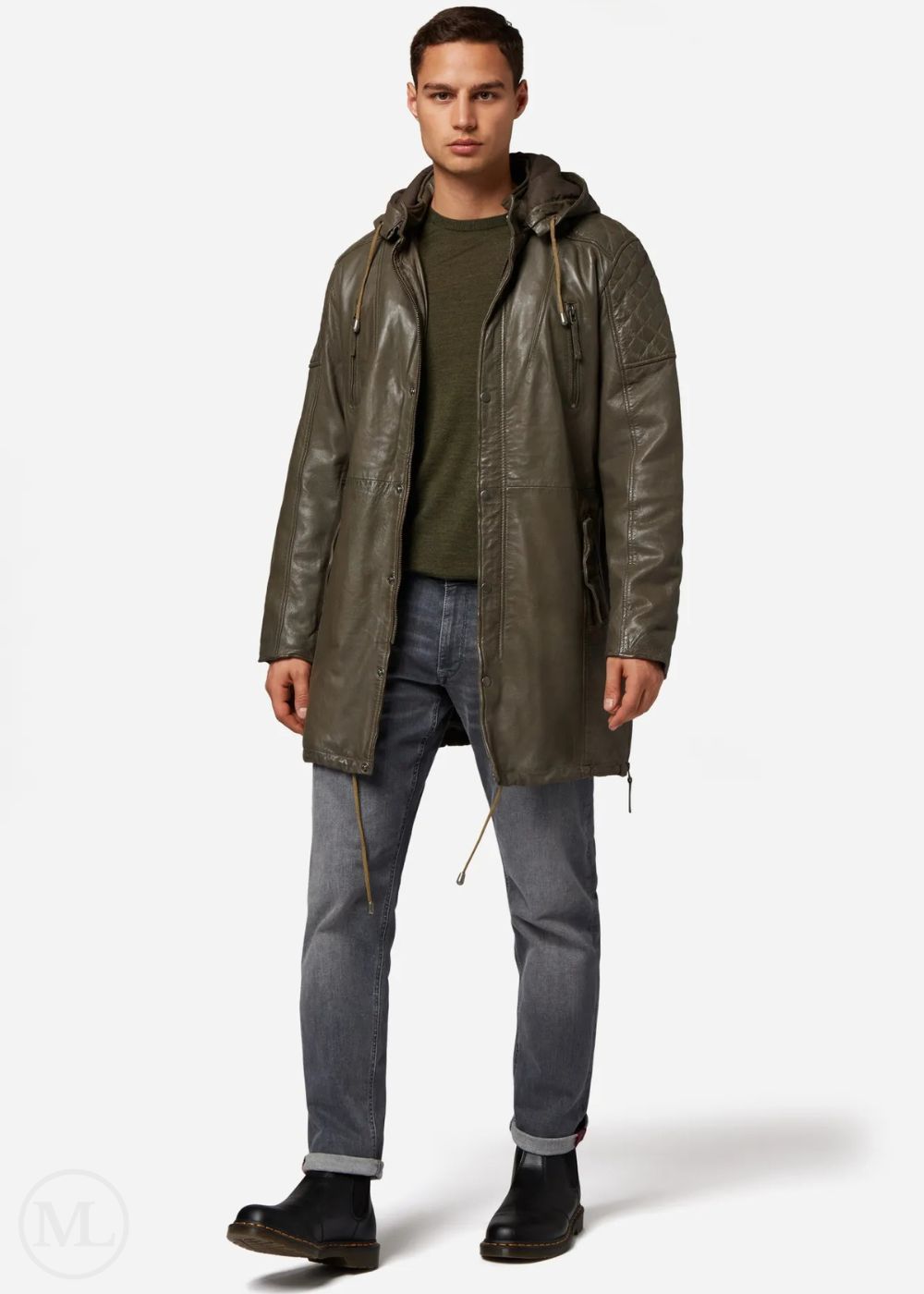 Man wearing a olive green leather coat, green shirt, and gray jeans on a white background