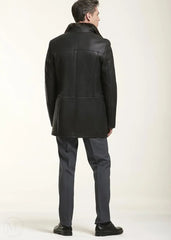 Man wearing a dark brown leather coat and gray pants on a white background