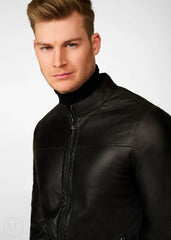 Man wearing a black leather biker jacket against a white background