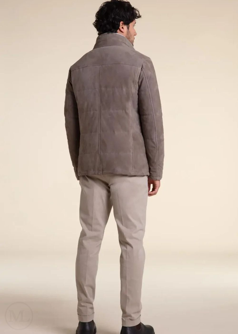 Man wearing a camel suede leather jacket and beige pants on a beige background