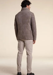 Man wearing a camel suede leather jacket and beige pants on a beige background