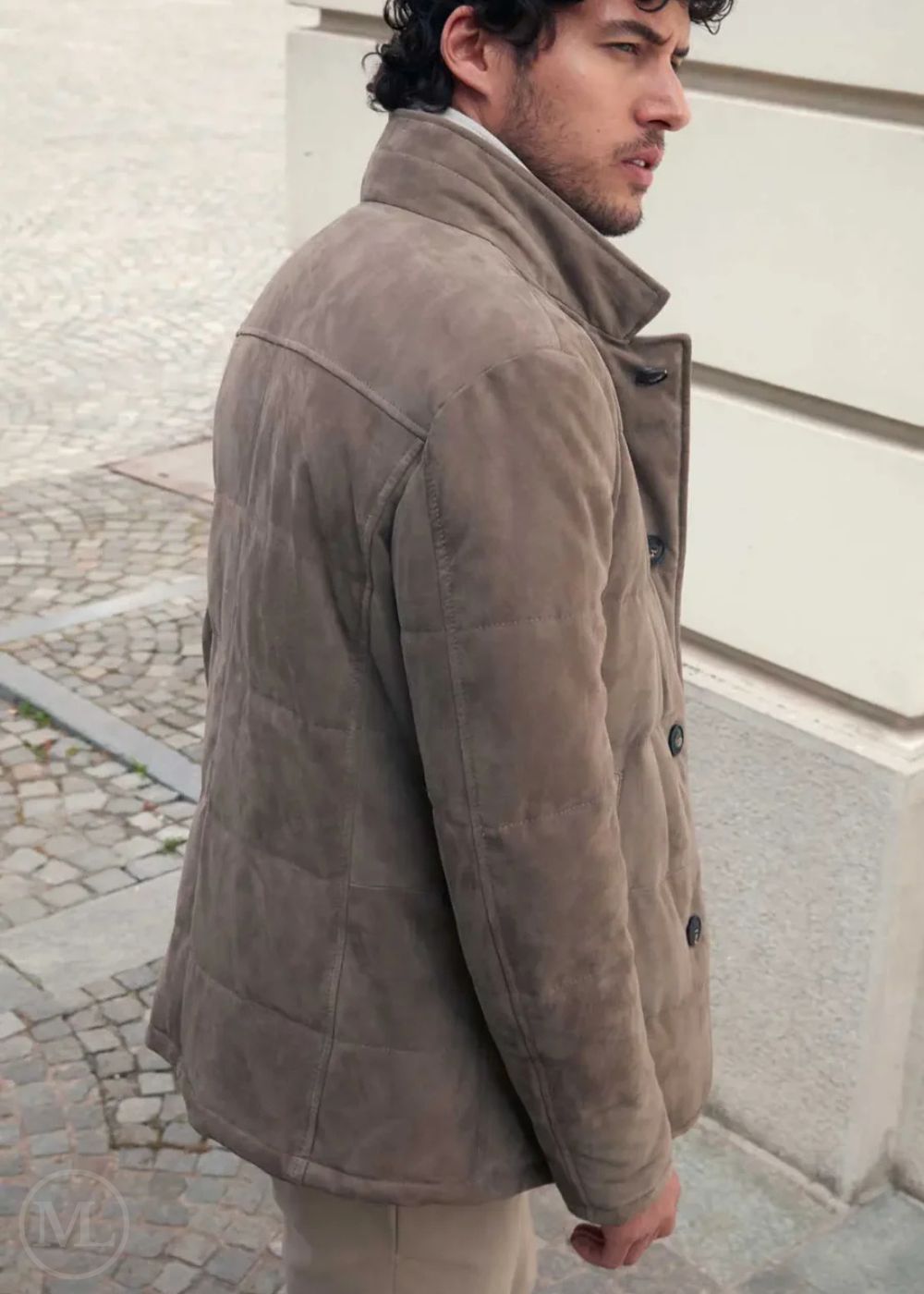 Man wearing a camel suede leather jacket standing on a street.
