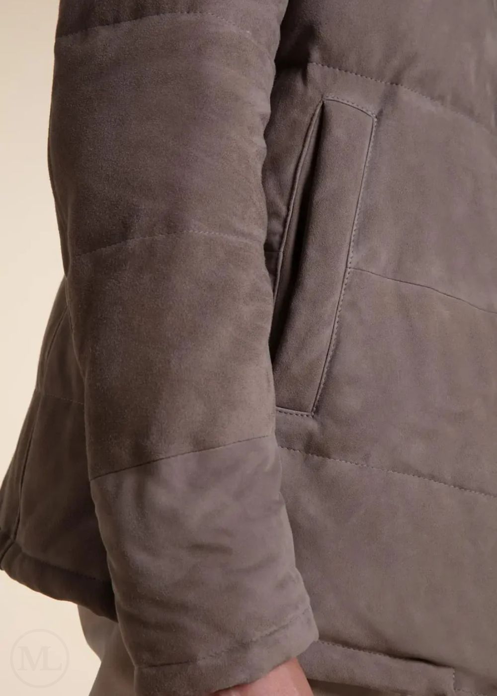 Close-up of a camel suede leather jacket with a focus on the sleeve and body worn by a man.