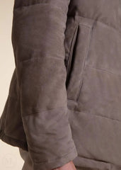 Close-up of a camel suede leather jacket with a focus on the sleeve and body worn by a man.