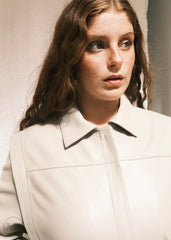 Woman wearing a Lvory Leather coat against a plain background