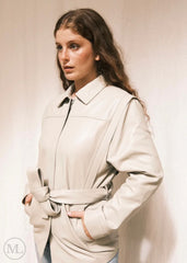 Woman wearing a Lvory Leather coat against a plain background