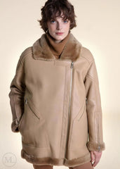 Woman wearing a camel Shearling leather coat with fur collar on a beige background