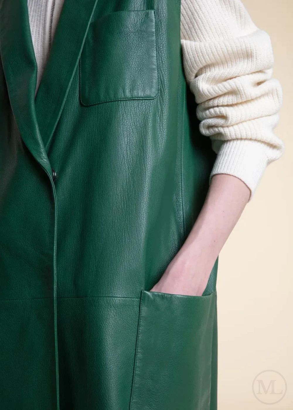 Emerald Green leather apron worn over a white sweater on a beige background