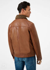 Man wearing a cognac brown leather jacket on a white background