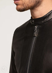 Close-up of a black leather jacket with a zipper on a neutral background
