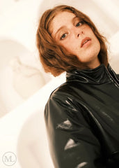 Women wearing a black leather Puffer jacket in front of white abstract art