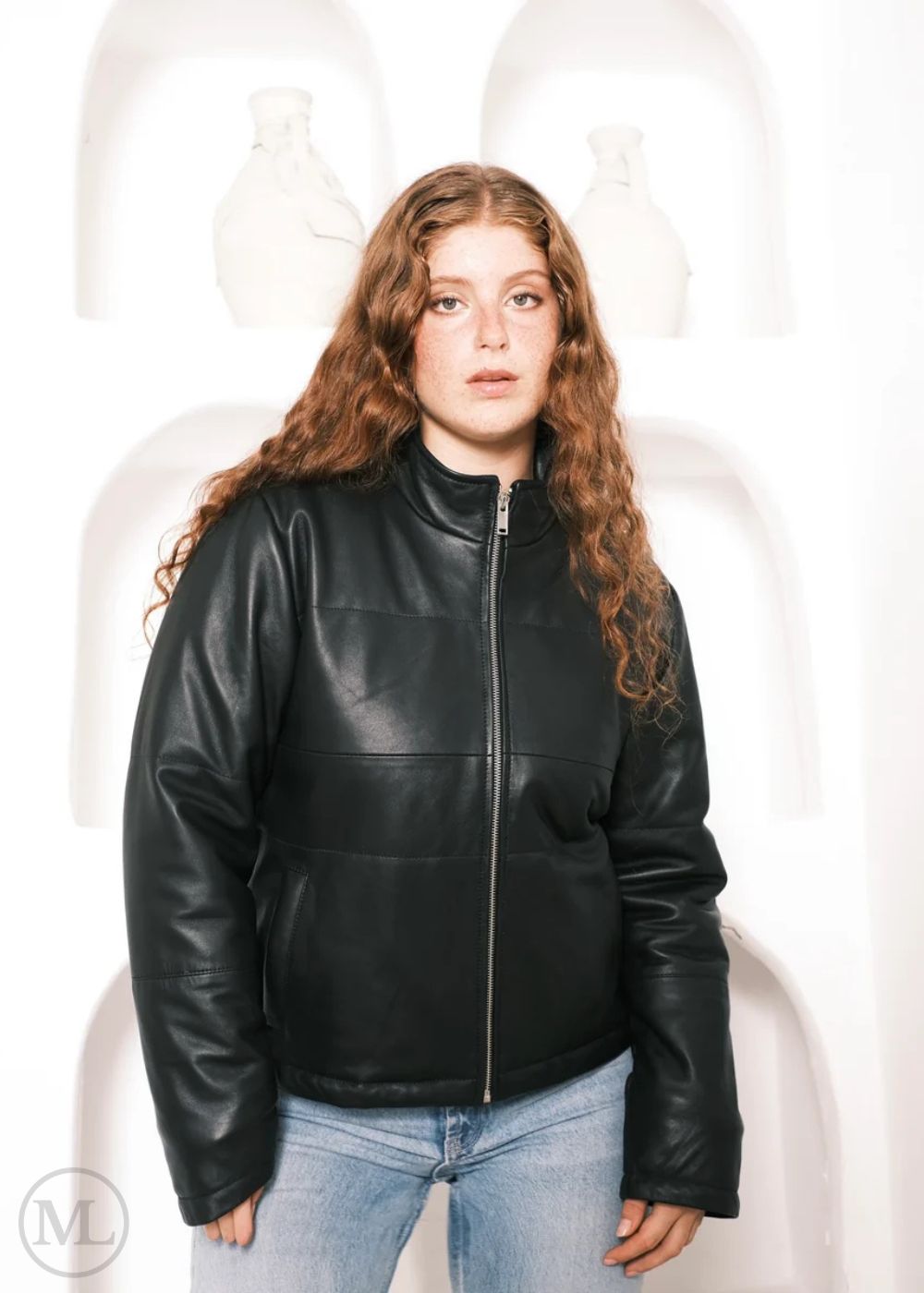 Women wearing a black leather down jacket against a white background, standing shot