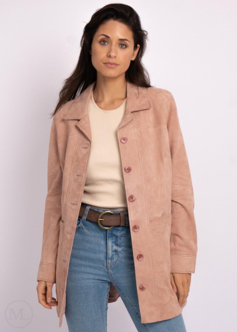 Woman wearing a pink laether coat, beige sweater, and blue jeans on a white background