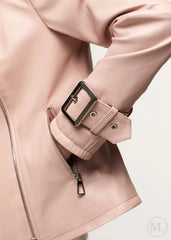 Close-up of a fuschia leather biker jacket with a black buckle on a light background