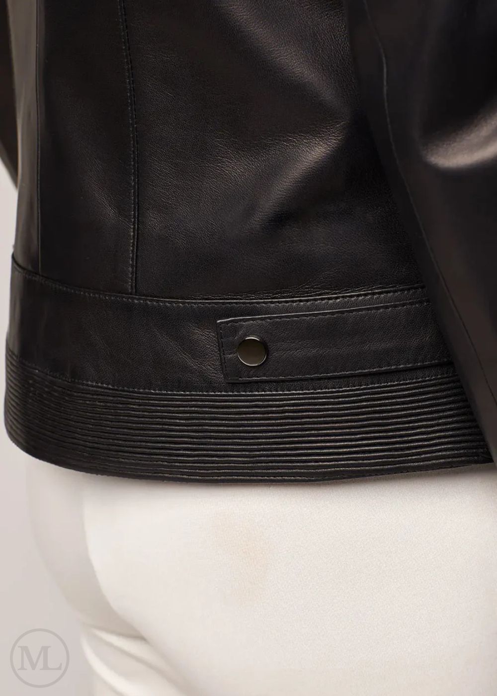 Close-up of a black leather biker jacket on a mannequin with a white background