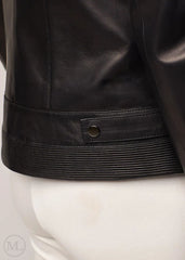 Close-up of a black leather biker jacket on a mannequin with a white background