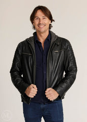 Man wearing a black leather Motorcycle  jacket over a dark shirt on a plain background