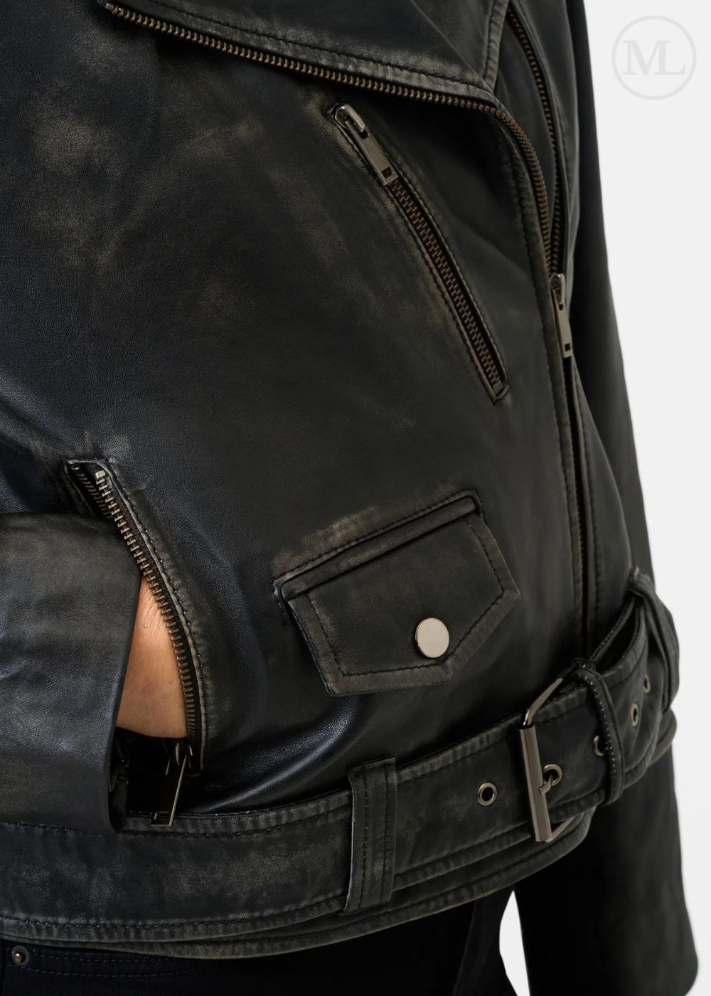 Close-up of a black leather biker jacket with zippers and a belt on a white background