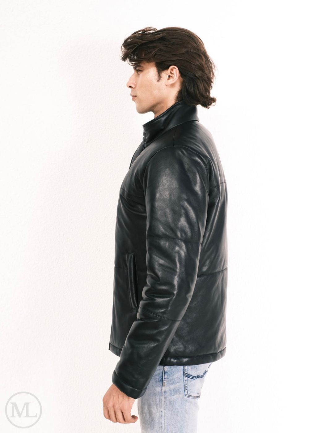 Man wearing a black leather down jacket on a white background, standing sideways