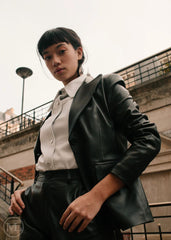 Women wearing a black leather Blazer jacket and black pants standing on a city street.