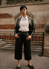 Women wearing a black leather Blazer jacket and black pants standing on a city street