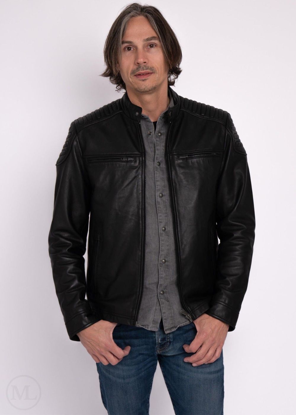 Man wearing a black leather jacket over a gray shirt on a white background