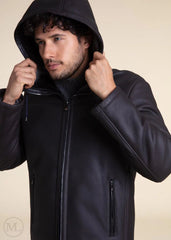 Man wearing a Dark Grey Hooded Shearling jacket with a hood against a beige background