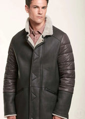 Man wearing a brown shearling leather jacket with white fur lining on a light background